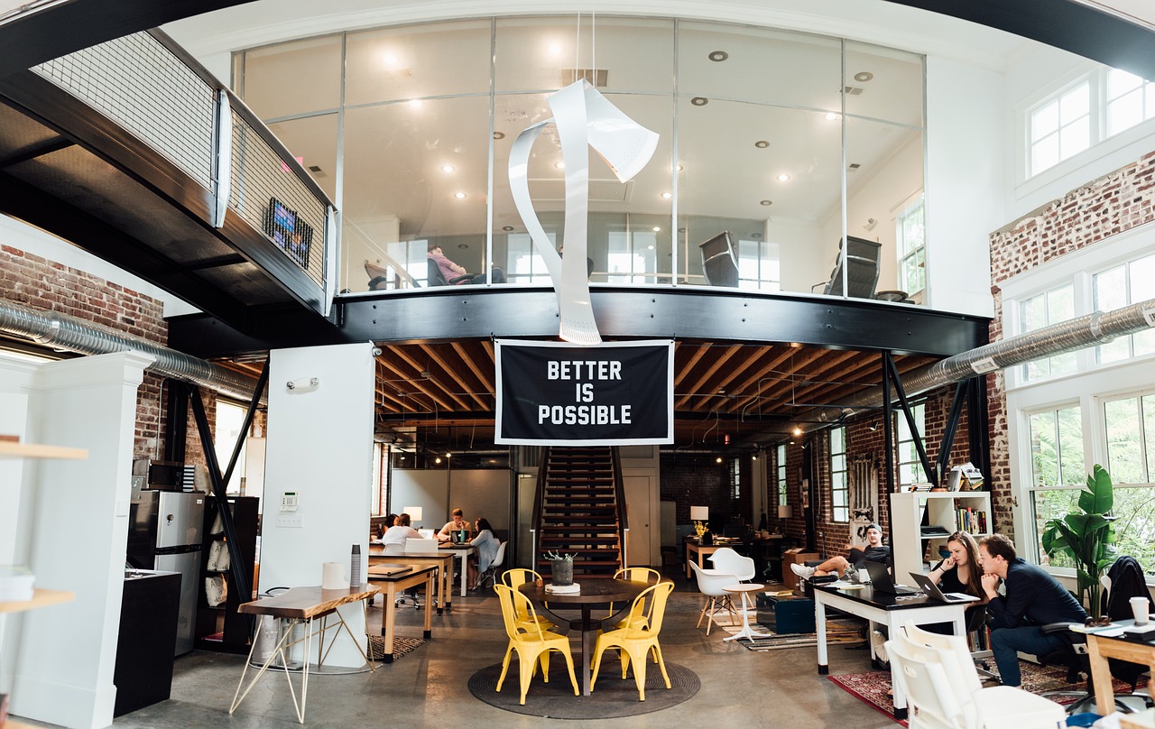 Better is Possible sign in an office with people working in the background.