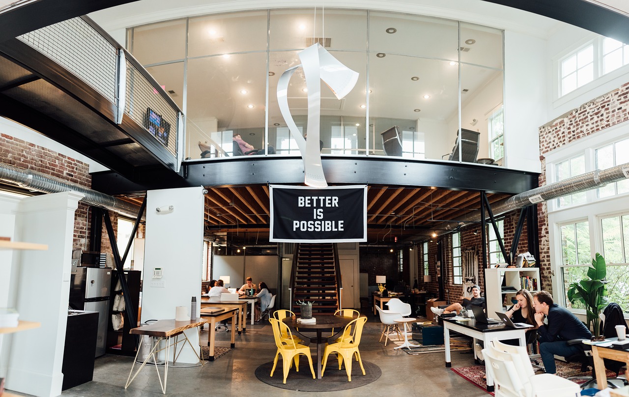 Better is Possible sign in an office with people working in the background. 